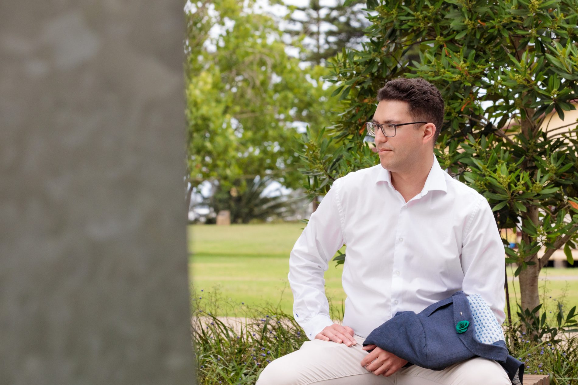 Ross Sergi sitting outdoors near the Newcastle foreshore